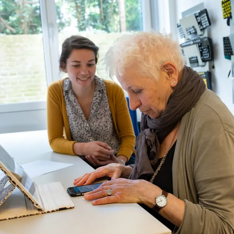 Een medewerker geeft ICT-advies over een tablet.